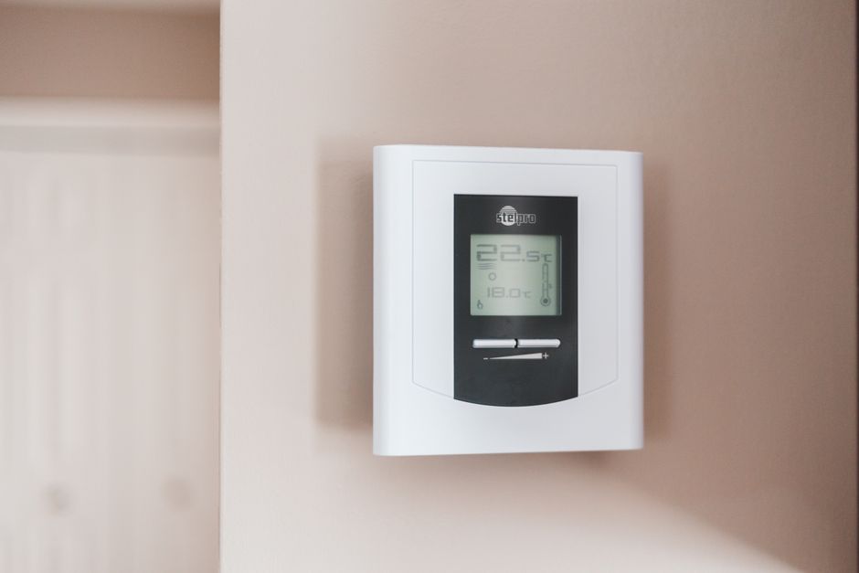 Moderne woonkamer met slimme thermostaat aan de muur. Moderne woonkamer met slimme thermostaat aan de muur.
